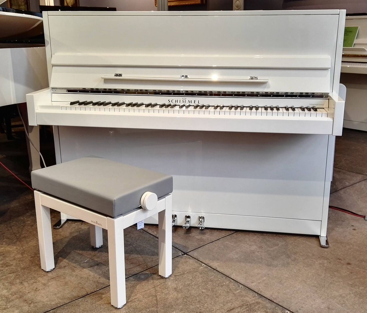 White upright Piano by Schimmel model International I115M