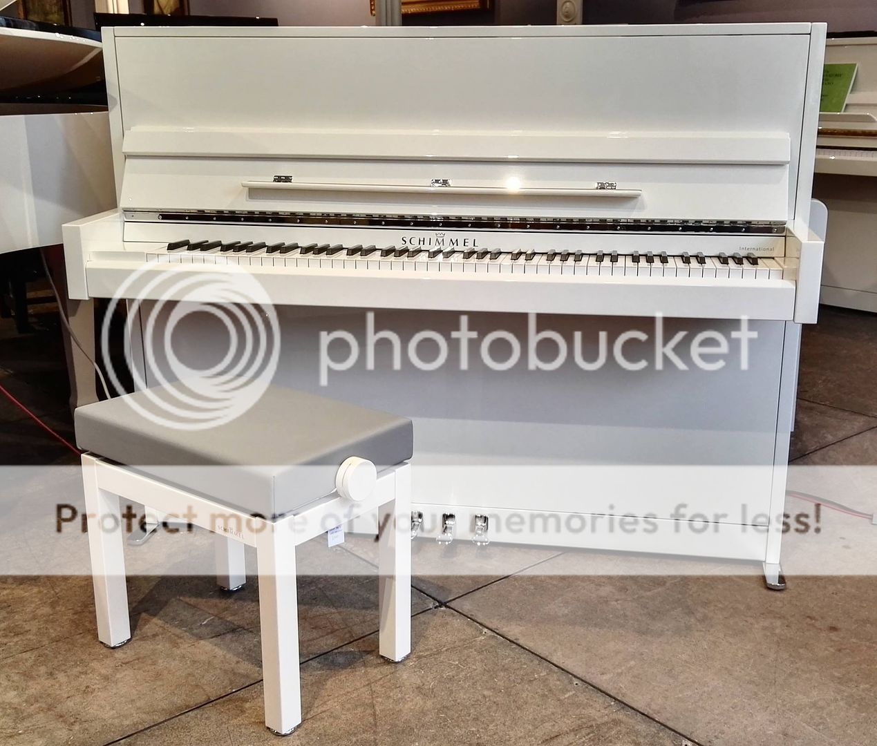 White upright Piano by Schimmel model International I115M